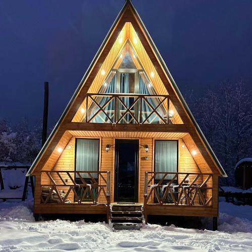 a cabin with a triangular roof in the snow at Villa Wood in Mestia N 2 in Mestia