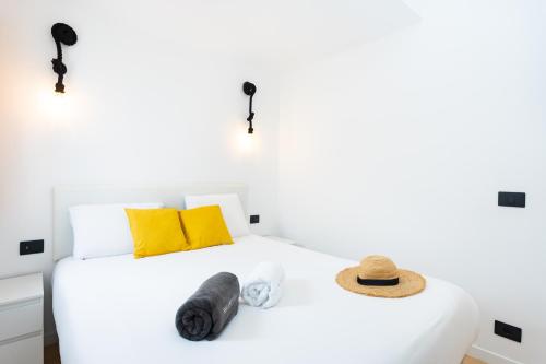 a bedroom with a white bed with a hat on it at Happy Home by Olax Rentals in Callao Salvaje