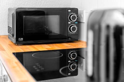 a microwave sitting on a counter next to a toaster oven at Modern Apartment - Accommodates 4 - On Street Parking Available 2CR in Birmingham