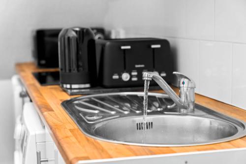 a kitchen sink with a faucet next to a microwave at Modern Apartment - Accommodates 4 - On Street Parking Available 2CR in Birmingham