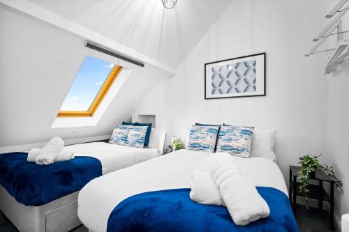 two beds in a small room with a window at Modern Apartment - Accommodates 4 - On Street Parking Available 2CR in Birmingham