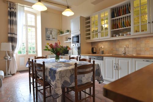 une cuisine avec une table et des chaises dans une cuisine dans l'établissement Maison Garésché, à Nieulle-sur-Seudre