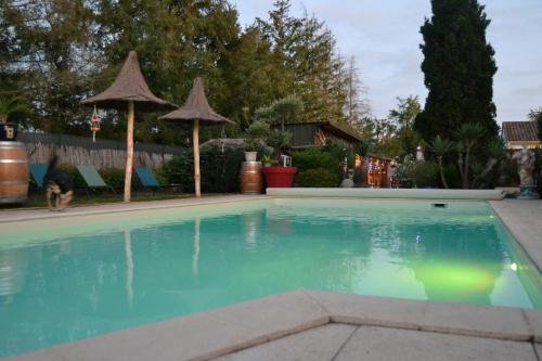 a swimming pool with blue water in a yard at Le gite de la Lombriere in Saint-Denis-de-Pile
