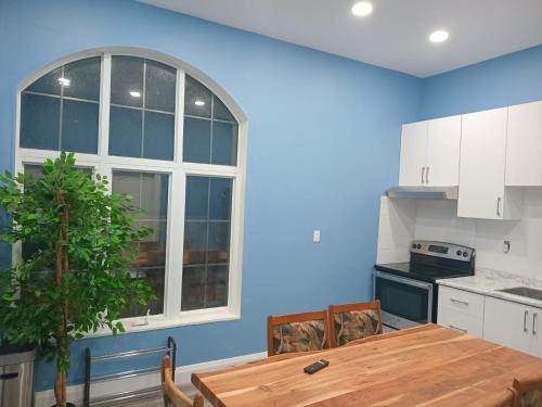 a kitchen with a wooden table and a blue wall at Windspire Inn in Port Elgin