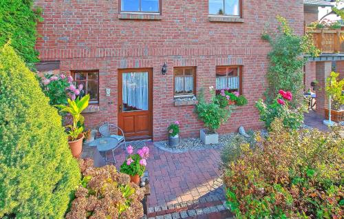a brick house with a patio with flowers and plants at Ferienwohnung Neustrelitz in Neustrelitz