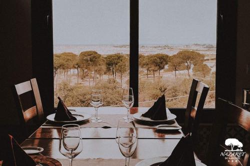 a table with wine glasses and a view of the savannah at Complejo Turístico Rural Nazaret De Moguer in Moguer
