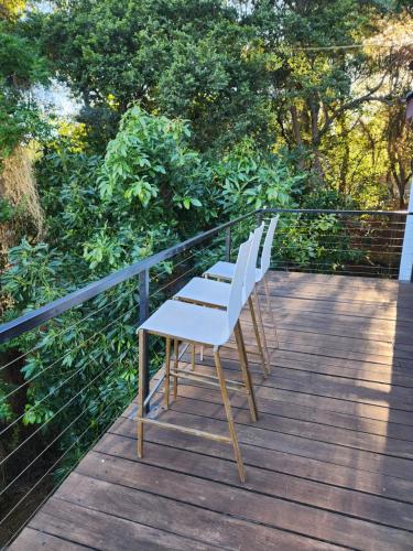 two white chairs sitting on top of a wooden deck at Le Bamboo Guest House And Boat Cruise in Hartbeespoort