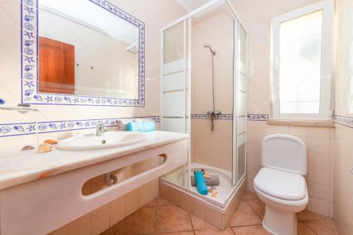 a bathroom with a sink and a toilet and a shower at Villa Azzurra by Algarve Vacation in Albufeira