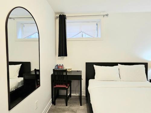 a bedroom with a mirror and a bed and a desk at A Home Away-Deluxe Guest Room in Toronto in Toronto