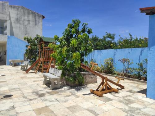 a patio with benches and a tree and a blue wall at Pousada Sol Nascente in Piranhas