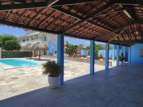 a patio with a wooden pergola and a swimming pool at Pousada Sol Nascente in Piranhas
