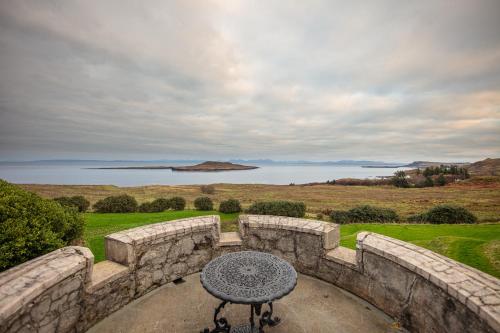 a stone patio with a table and a view of the water at Flodigarry Hotel in Staffin