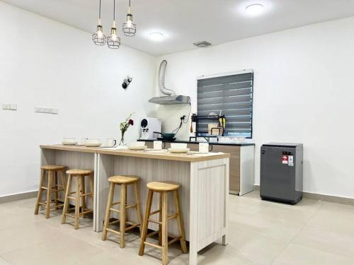 a kitchen with a counter with stools around it at 16Pax House Landed Setia Alam Mall SCCC Wi-Fi TV in Shah Alam