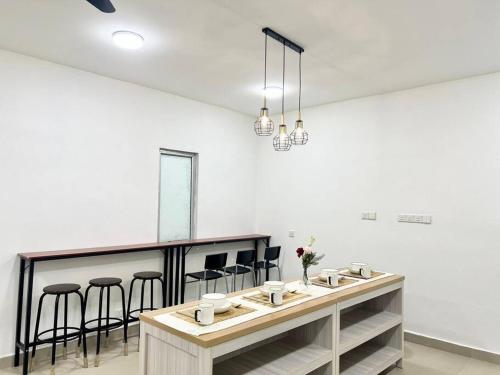 a white room with a counter with bar stools at 16Pax House Landed Setia Alam Mall SCCC Wi-Fi TV in Shah Alam