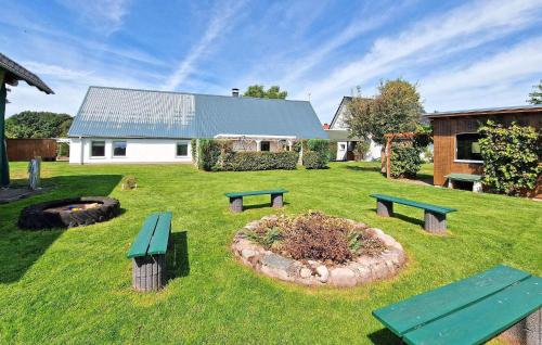 a yard with three picnic benches and a flower bed at Doppelhaushälfte Mirow Starsow in Starsow