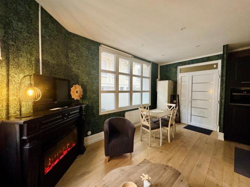 un salon avec une cheminée et une table dans l'établissement Le Besson, 2 pièces au cœur de la ville, à Trouville-sur-Mer