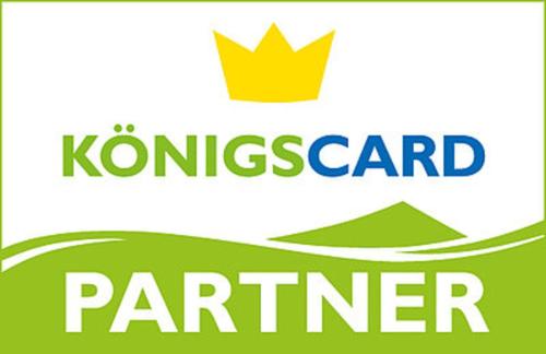 Un logotipo para el centro de coches Konungs con una corona. en Wildgrün Panorama Lodge 1, en Pfronten