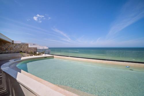 a swimming pool with a view of the ocean at 4 Bedroom Siela Beachfront Luxury Apartment in San Bruno