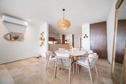 a dining room with a white table and chairs at 4 Bedroom Siela Beachfront Luxury Apartment in San Bruno