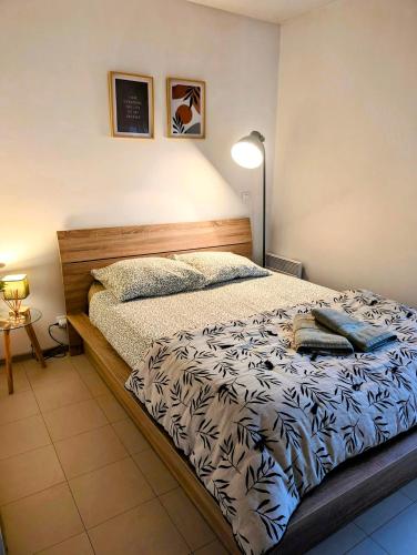 - une chambre avec un lit et une lampe dans l'établissement L'instant sorgue, à LʼIsle-sur-la-Sorgue