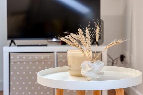 une table blanche avec un vase au-dessus dans l'établissement Bertille studio atypique en centre ville, à Rouen