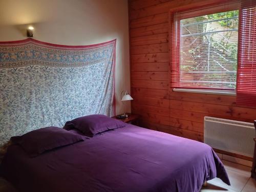 une chambre avec un lit violet et une fenêtre dans l'établissement La Maison Du Coteau, à Cachan