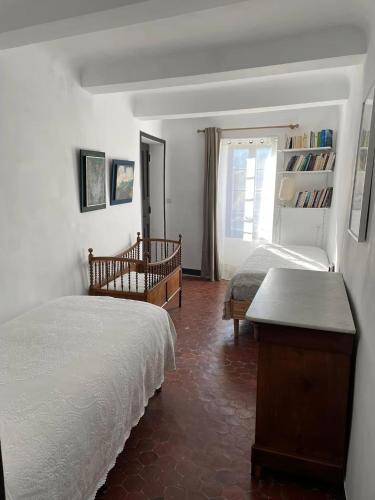 a bedroom with two beds and a window at La Maison Joly in Ménerbes