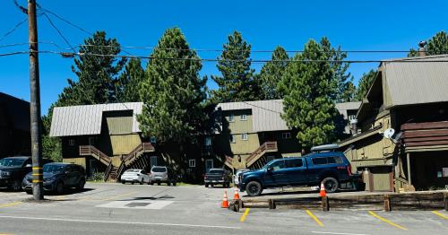 a blue truck parked in a parking lot next to buildings at Cozy Condo in Mammoth with 2 parking spots! Ski,Snowboard, Ice skate! in Mammoth Lakes