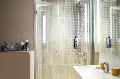 une salle de bain avec douche et lavabo dans l'établissement ibis Paris Ornano Montmartre Nord 18ème, à Paris