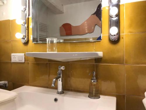 a bathroom sink with a mirror and a faucet at La Maison Joly in Ménerbes