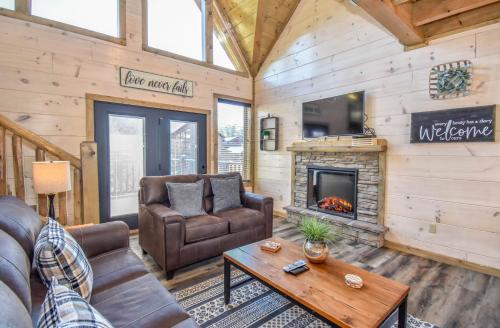 a living room with leather furniture and a fireplace at Luxury 4-BR Cabin Near Parkway and Dollywood with Game Room and Hot Tub in Pigeon Forge
