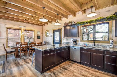 a kitchen with wooden ceilings and a dining room with a table at Luxury 4-BR Cabin Near Parkway and Dollywood with Game Room and Hot Tub in Pigeon Forge