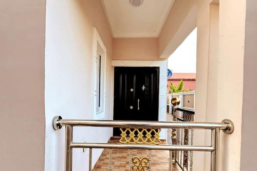 a hallway with a metal railing in front of a black door at Cozy & Serene Sanctuary -The Paletinos Homes in Umuahia