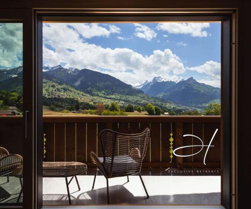 einen Balkon mit 2 Stühlen und Bergblick in der Unterkunft Hidden Retreats Alpine Edge in Aeschi