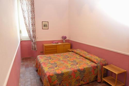 a small bedroom with a bed and a table at Holiday House Taormina in Trappitello