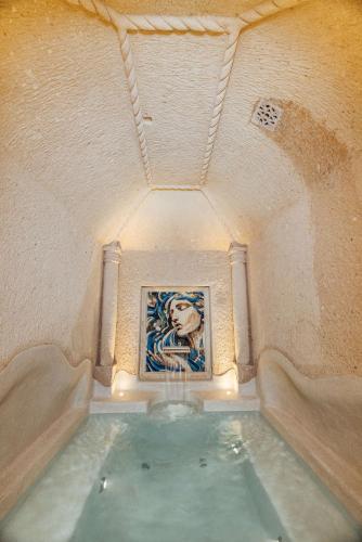 a pool of water in a room with a painting at Via Regia Cappadocia Hotel in Uchisar