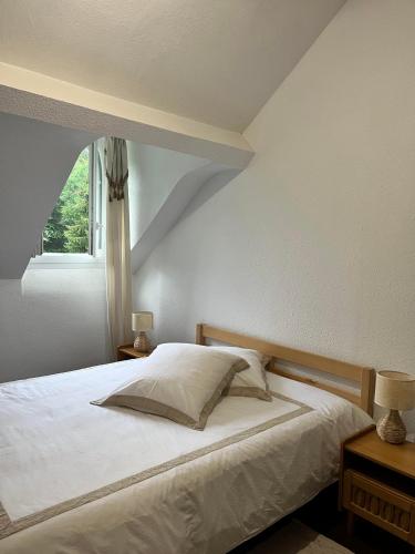 une chambre avec un lit blanc avec une fenêtre dans l'établissement Villa Julia, à Capvern