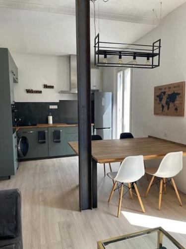une pièce avec une table et des chaises et une cuisine dans l'établissement tres bel appartement au calme entre gare et centre, à Perpignan