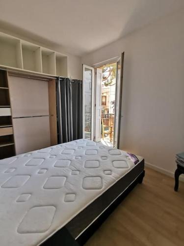 une chambre avec un grand lit dans une pièce dans l'établissement tres bel appartement au calme entre gare et centre, à Perpignan