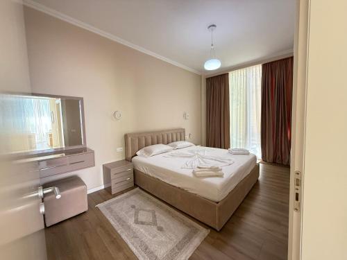 a bedroom with a bed and a flat screen tv at Villa Harmony Green Coast, Palase in Himare