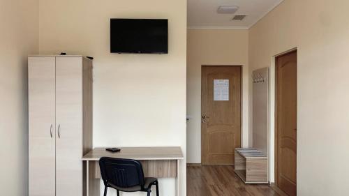 a room with a desk and a tv on the wall at Budget Hotel Ekotel in Lviv