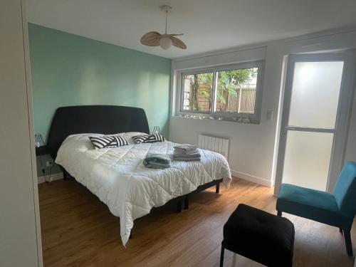 - une chambre avec un lit, une fenêtre et un ventilateur dans l'établissement L’Auguste - Appartement Terrasse, 450m de la plage, à Royan