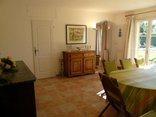 une salle à manger avec une table et des chaises vertes dans l'établissement nice family vacation house with heated swimming pool, in mouries, alpilles areas 10 persons, à Mouriès
