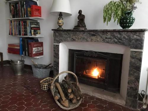a fireplace in a living room with a fire in it at La Maison Joly in Ménerbes