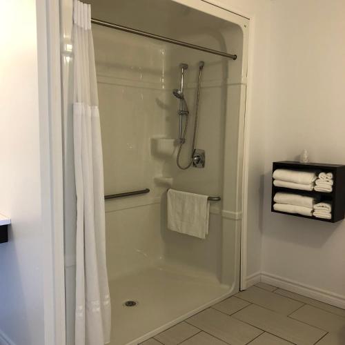 ein Bad mit Dusche und Duschvorhang in der Unterkunft Kow's Inn in Bras D'or