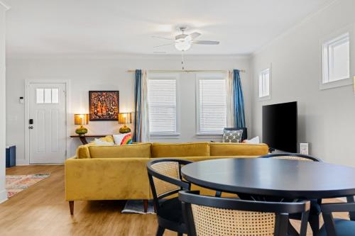 a living room with a yellow couch and a table at Family-Friendly 4BR with Fenced Yard & Parking in Durham