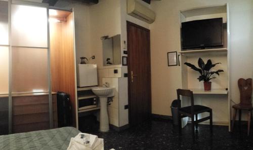 a hotel room with a bed and a table and a bathroom at La Casa del Viandante in Modena