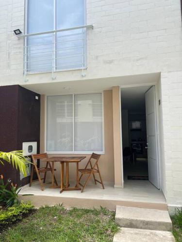 a patio with a wooden table in front of a building at Hermosa casa muy equipada en condominio in Ricaurte