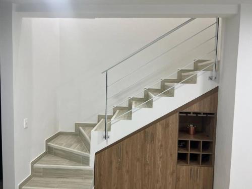 a staircase in a house with a glass wall at Hermosa casa muy equipada en condominio in Ricaurte