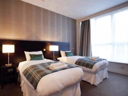 um quarto de hotel com duas camas e uma janela em The Golden Acorn Wetherspoon em Glenrothes